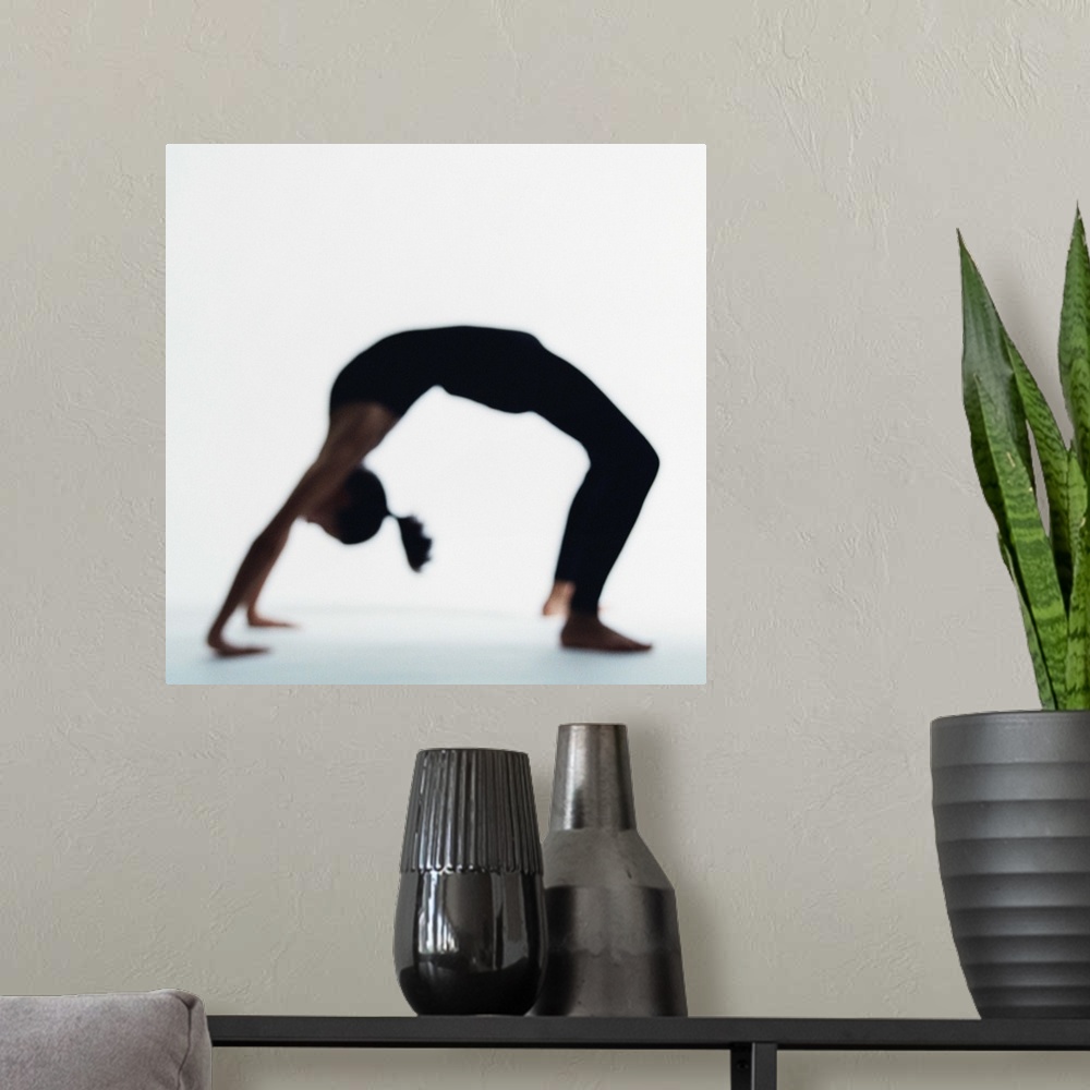 A modern room featuring Woman in yoga backbend pose