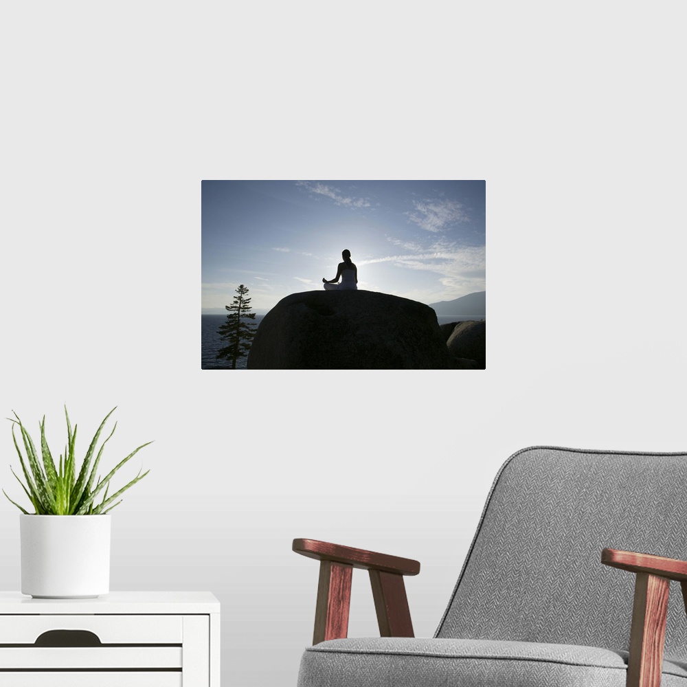A modern room featuring Woman meditating on rock