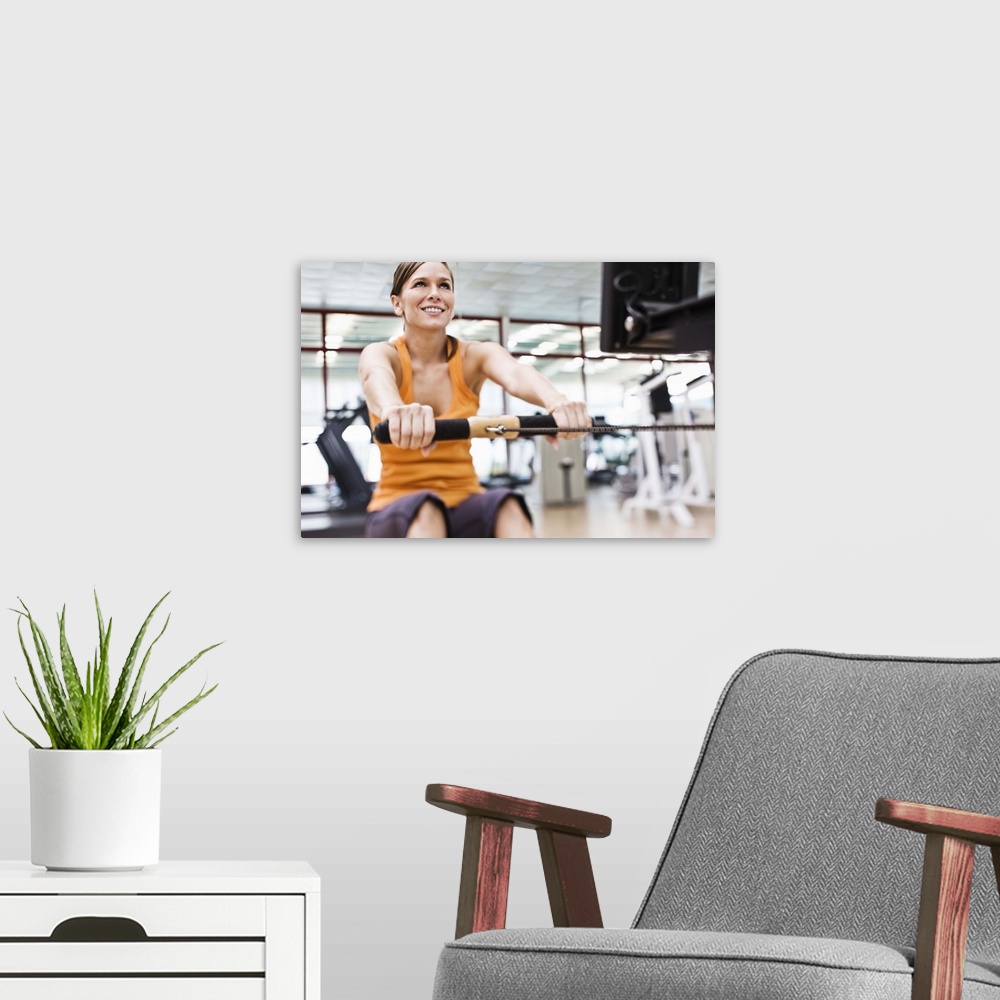 A modern room featuring Woman on rowing machine