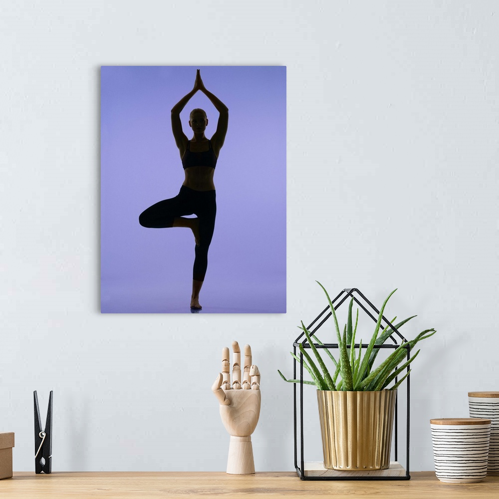 A bohemian room featuring girl doing yoga stretches in silouette on purple background