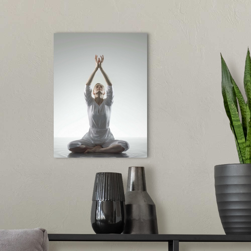 A modern room featuring Woman sitting in yoga position in water