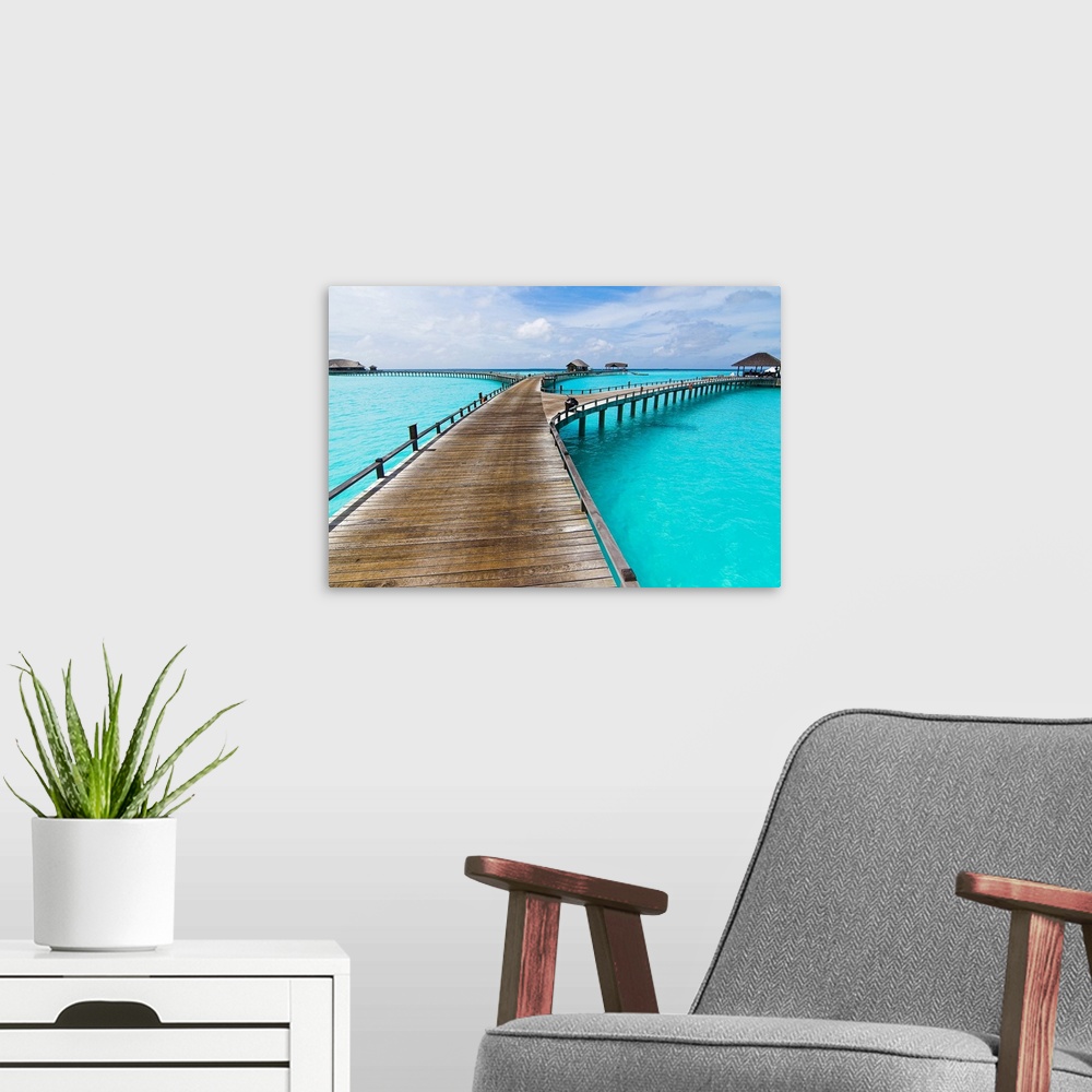 A modern room featuring This wide angle landscape photograph shows a tropical destination of small huts and gazebos acces...