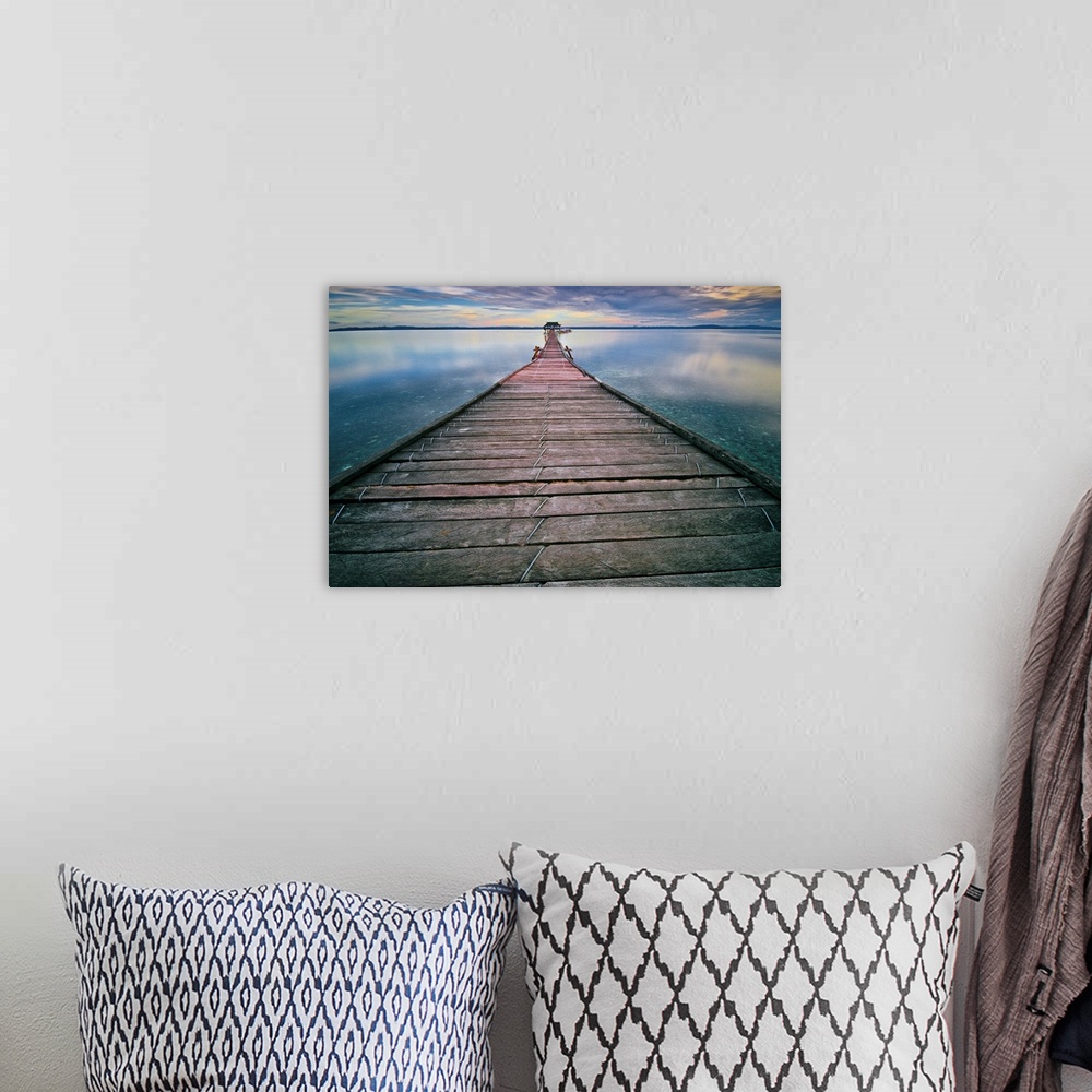 A bohemian room featuring Wall art of a long pier leading out into the calm water.