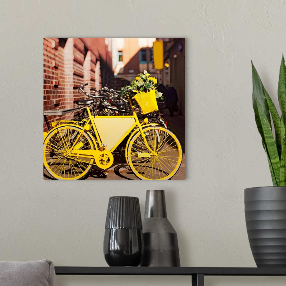 A modern room featuring Yellow bike with sunflowers parked outside.
