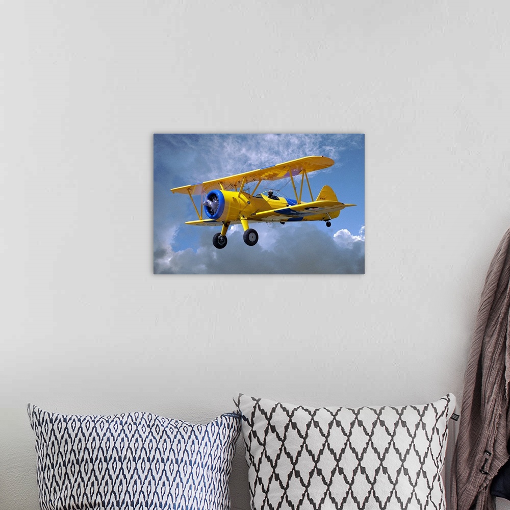 A bohemian room featuring Yellow Stearman 5YP bi-plane flying in cloudy sky