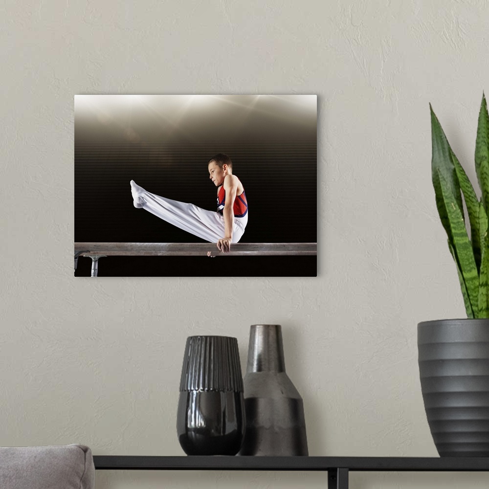 A modern room featuring Young male gymnast performing on parallel bars