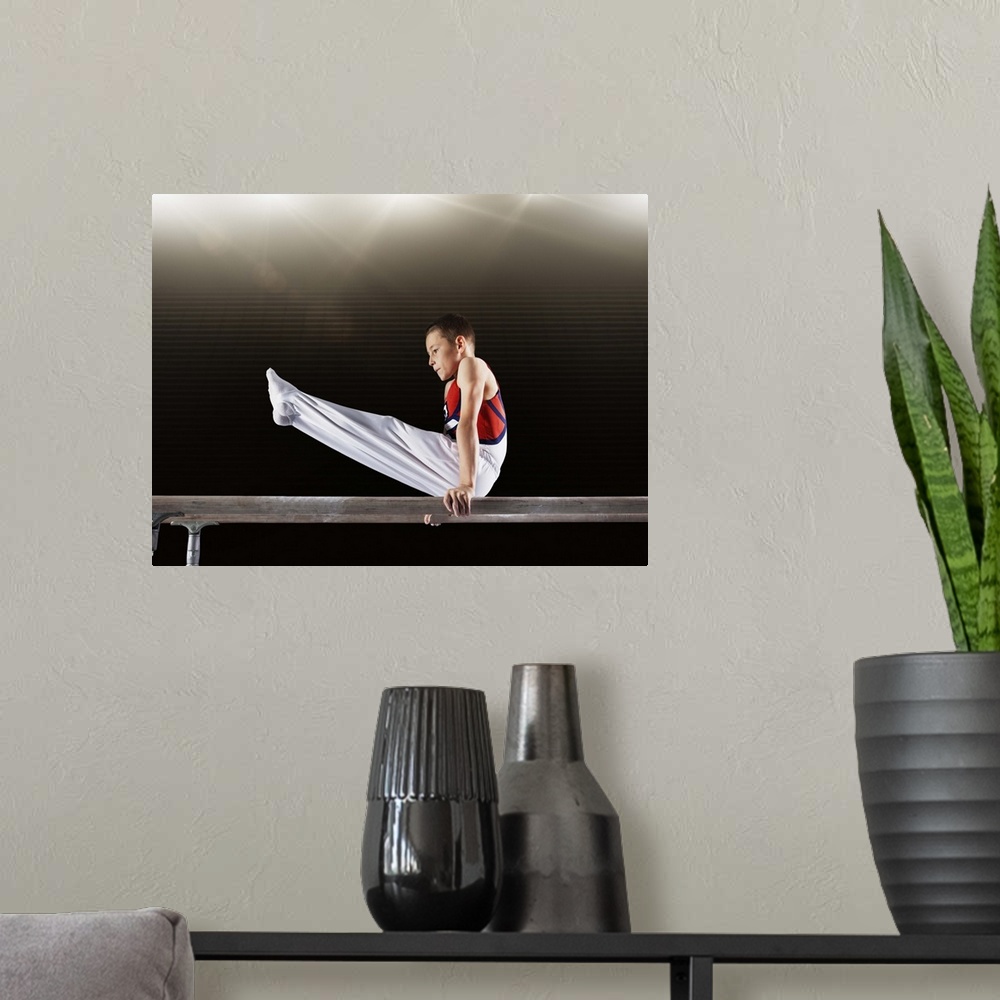 A modern room featuring Young male gymnast performing on parallel bars