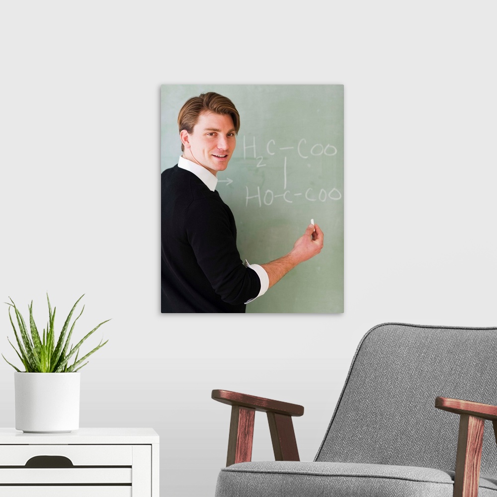 A modern room featuring USA, New Jersey, Jersey City, young teacher writing equation on blackboard