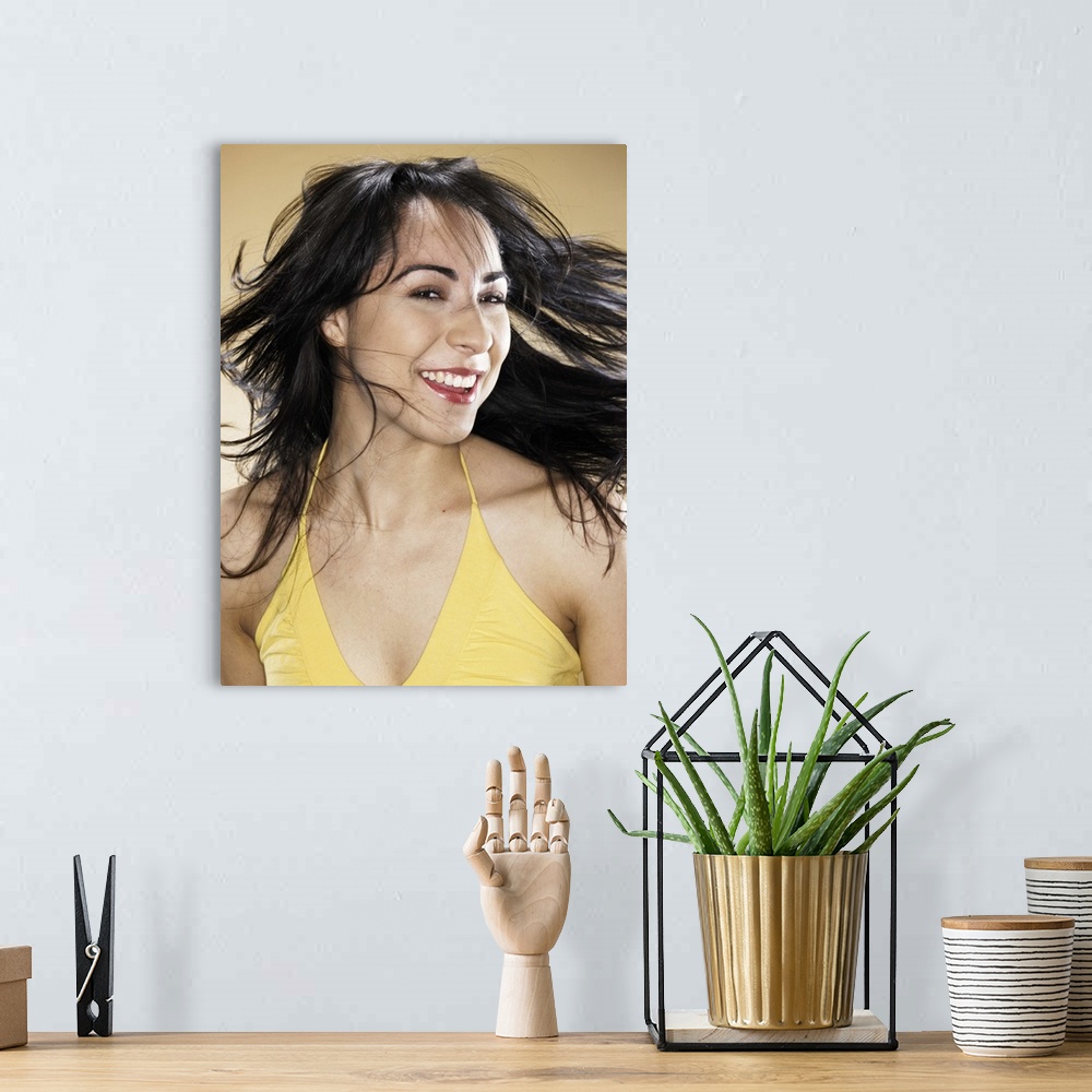 A bohemian room featuring Young woman tossing hair, smiling, portrait, head and shoulders