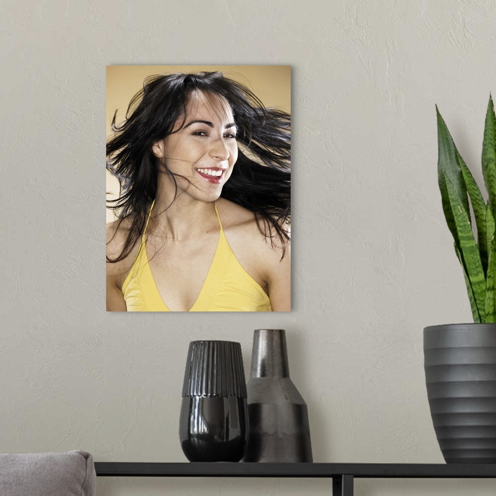 A modern room featuring Young woman tossing hair, smiling, portrait, head and shoulders