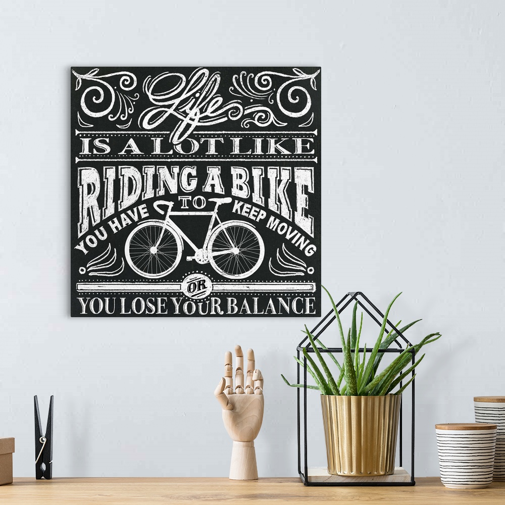 A bohemian room featuring Typography artwork in a chalkboard style reading "Life is a lot like riding a bike, you have to k...