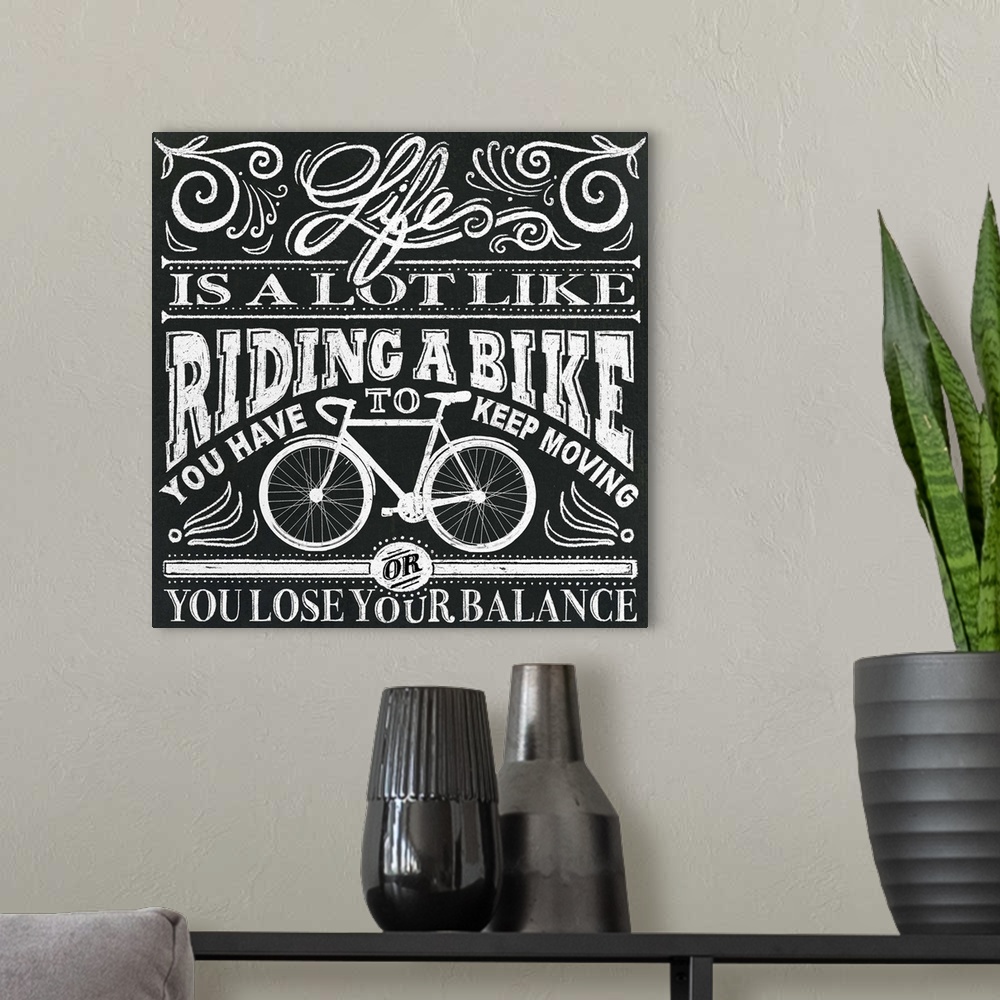 A modern room featuring Typography artwork in a chalkboard style reading "Life is a lot like riding a bike, you have to k...