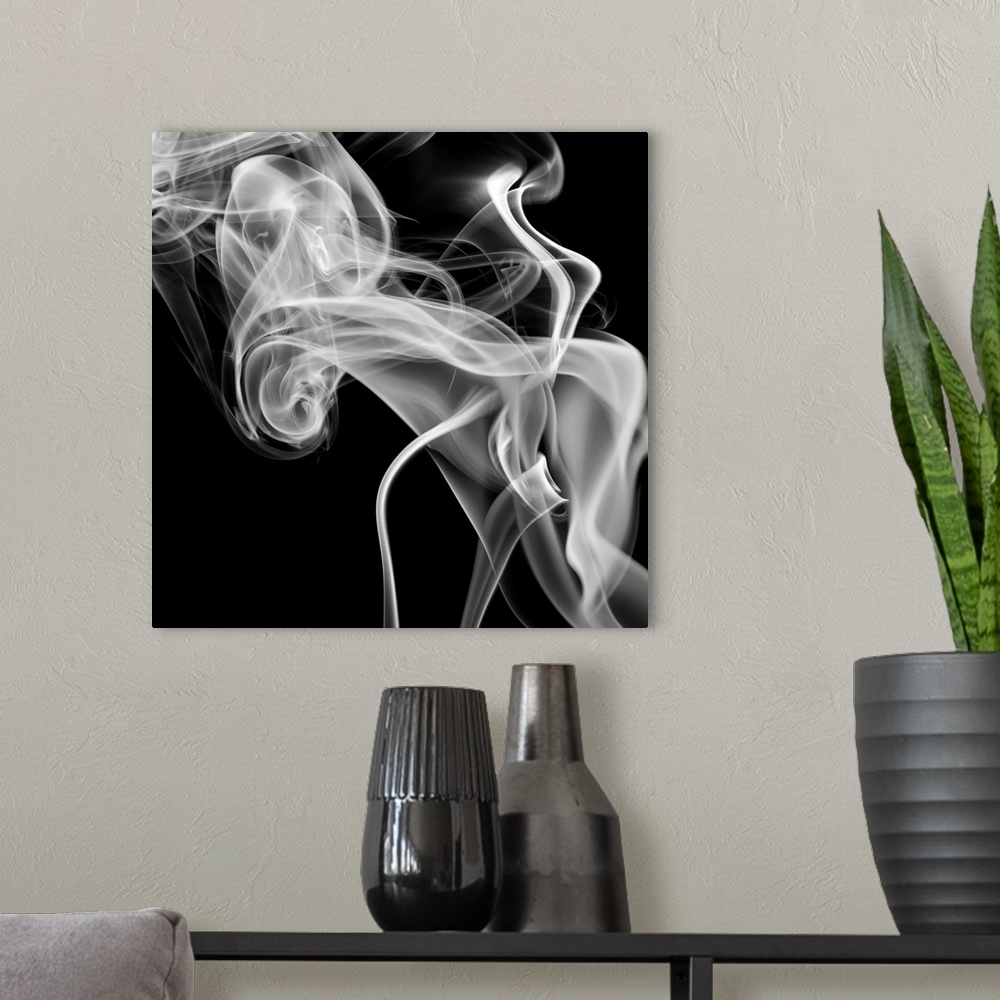 A modern room featuring Square, oversized, big canvas art of a large cloud of smoke swirling on a solid black background.