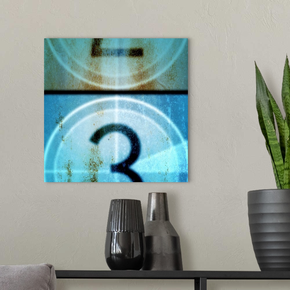 A modern room featuring Square, large vintage wall hanging of a filmstrip countdown that is between two and three, covere...