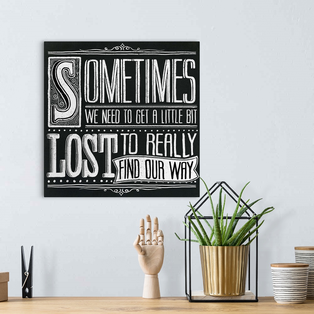 A bohemian room featuring Typography artwork in a chalkboard style reading "Sometimes we need to get a little bit lost to r...
