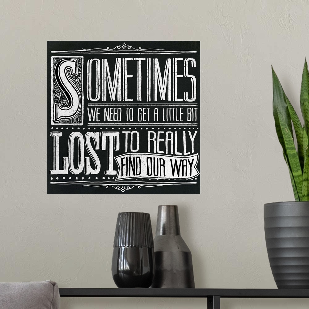 A modern room featuring Typography artwork in a chalkboard style reading "Sometimes we need to get a little bit lost to r...