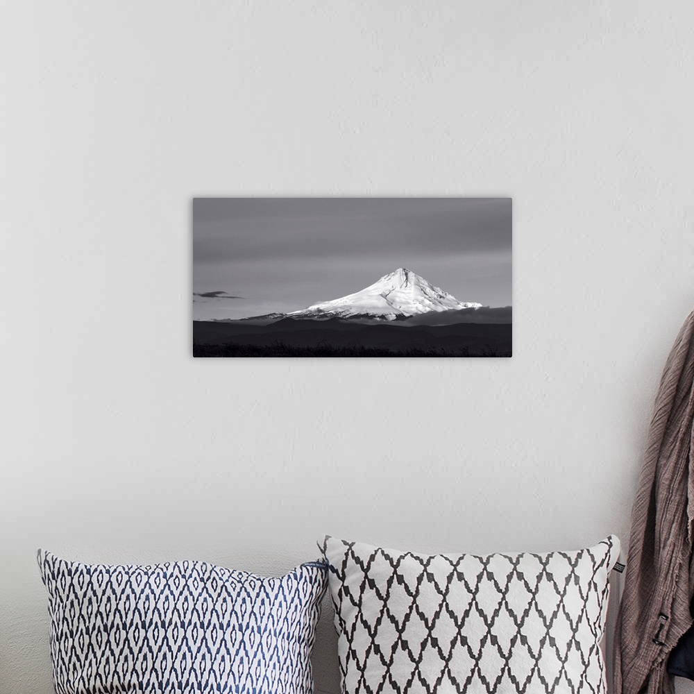 A bohemian room featuring A black and white photograph of a Mt. Hood under a smooth gray sky.