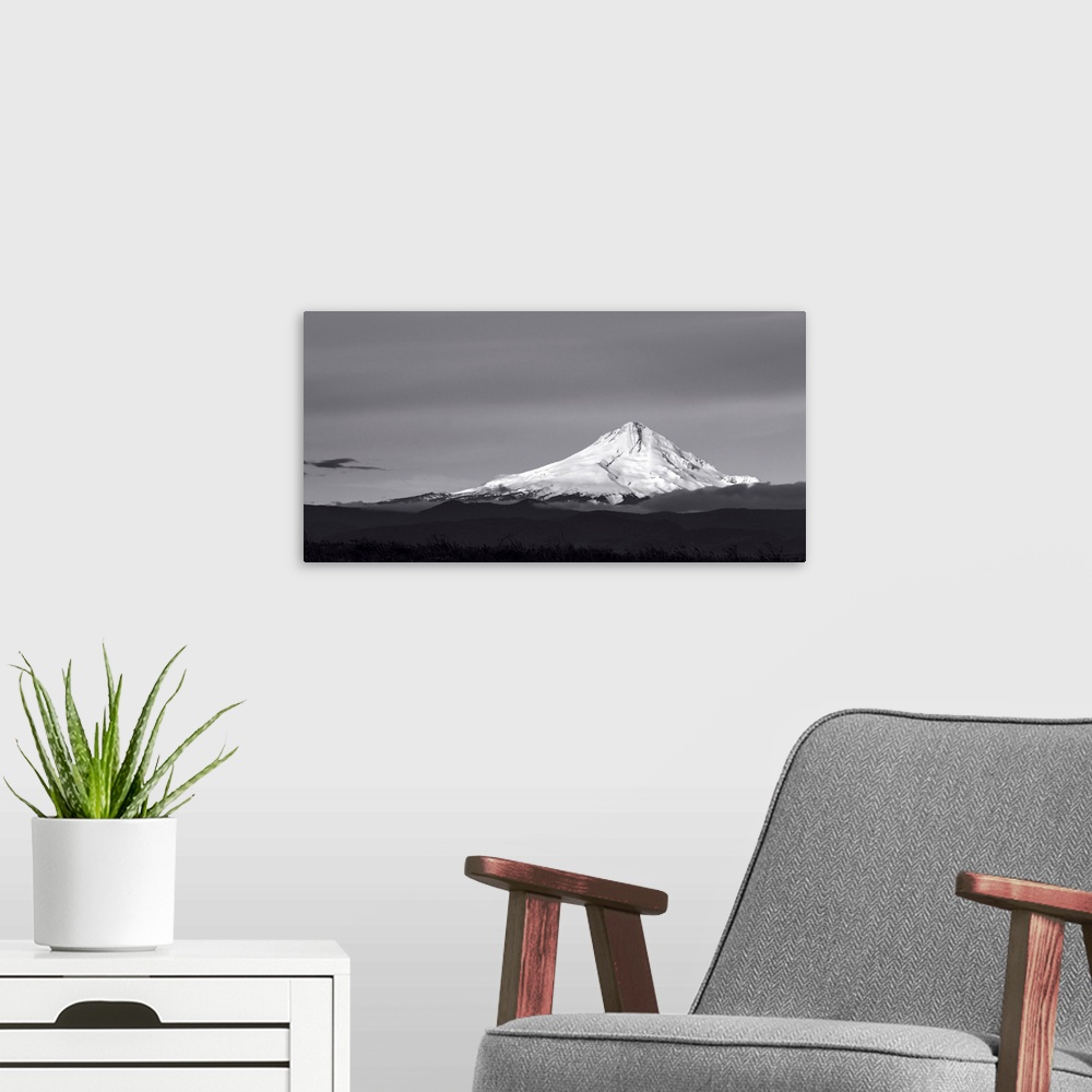 A modern room featuring A black and white photograph of a Mt. Hood under a smooth gray sky.