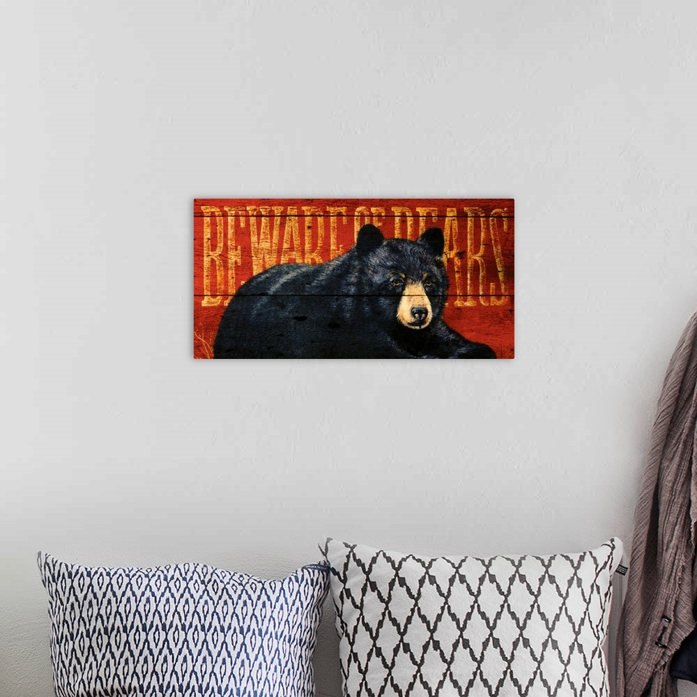 A bohemian room featuring Artwork of a black bear sitting on the ground with the warning ""Beware of Bears"" written behind...