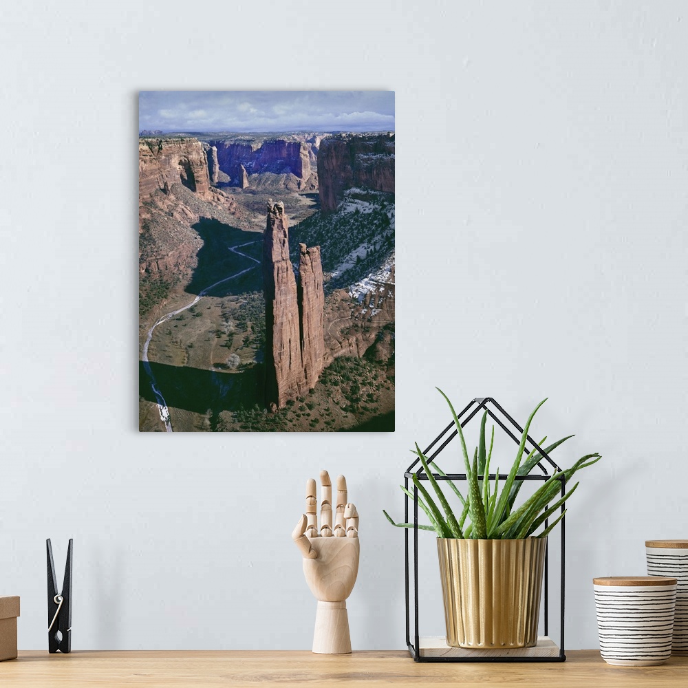 A bohemian room featuring A photograph of a towering rock formation in a desert canyon.