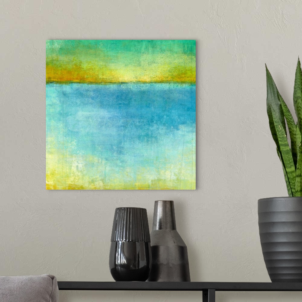 A modern room featuring Abstract artwork resembling a lake and horizon in blue, yellow, and green shades.