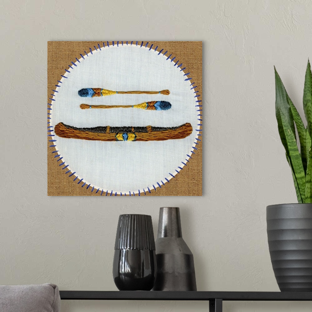 A modern room featuring Contemporary embroidered artwork of a canoe sewn onto a white circle against a brown background.
