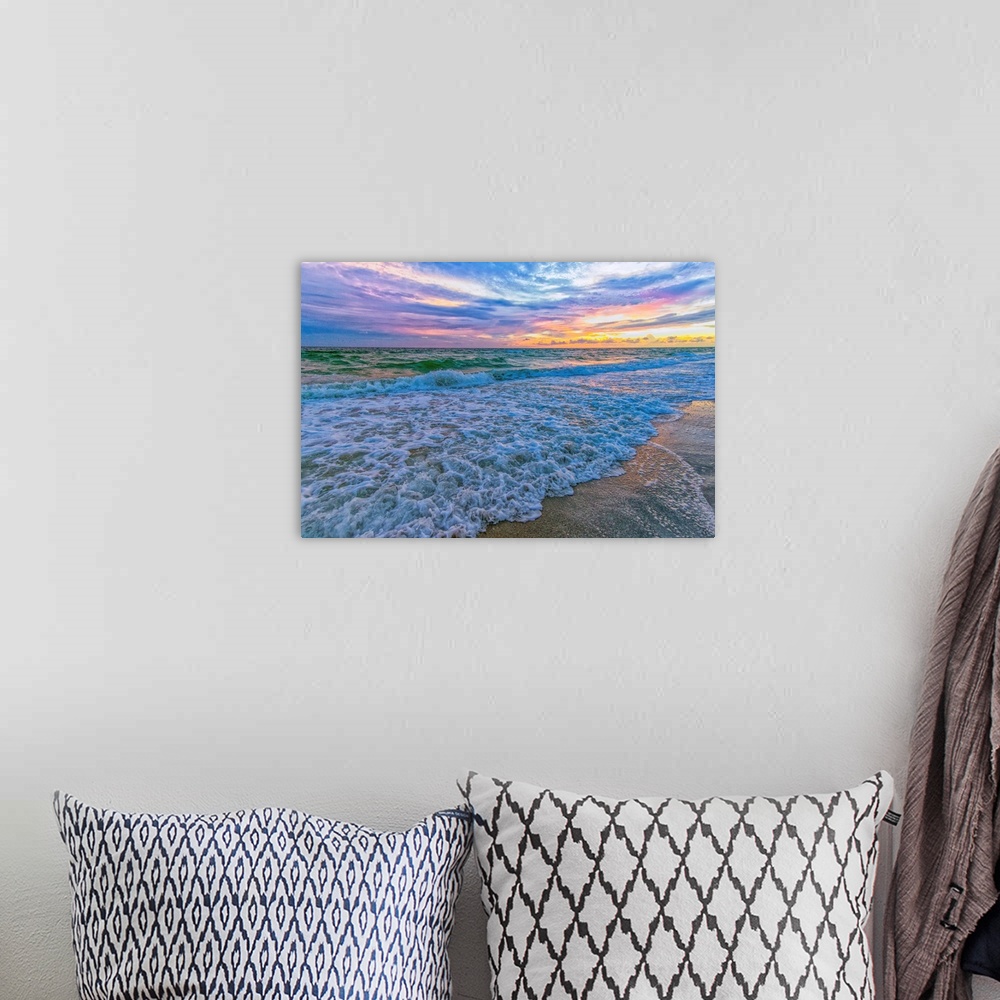 A bohemian room featuring A fine art photograph of a calm sea washing up onto a sandy beach. The sunrise provides an abunda...