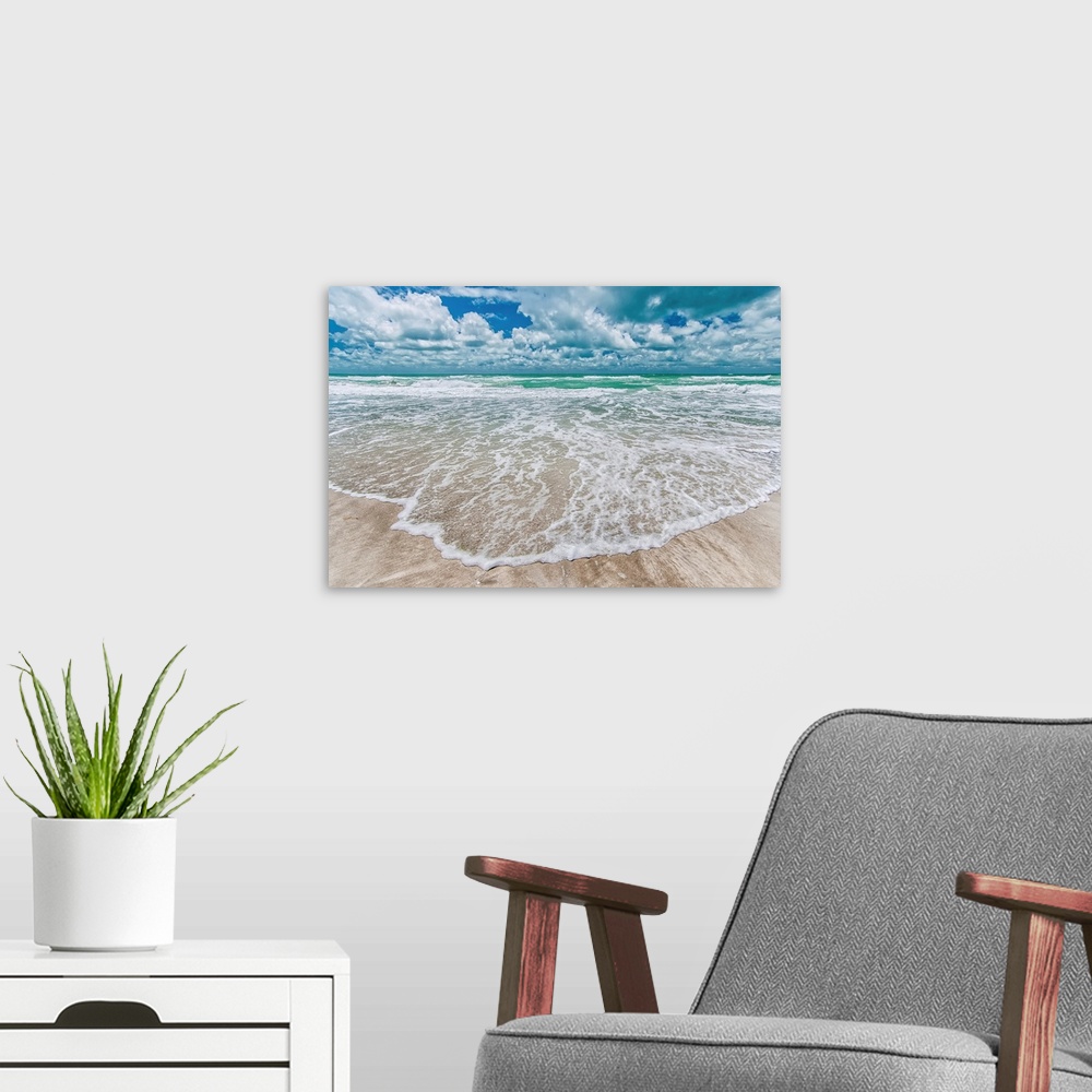 A modern room featuring Gentle waves wash onto a sandy beach in this summery photography