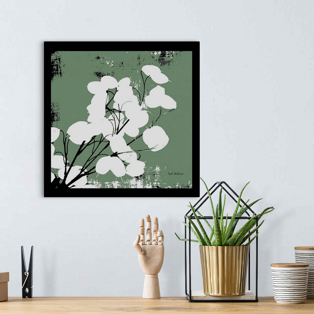 A bohemian room featuring Square silhouetted painting of a money plant in dusty green, black, and white with a black boarder.