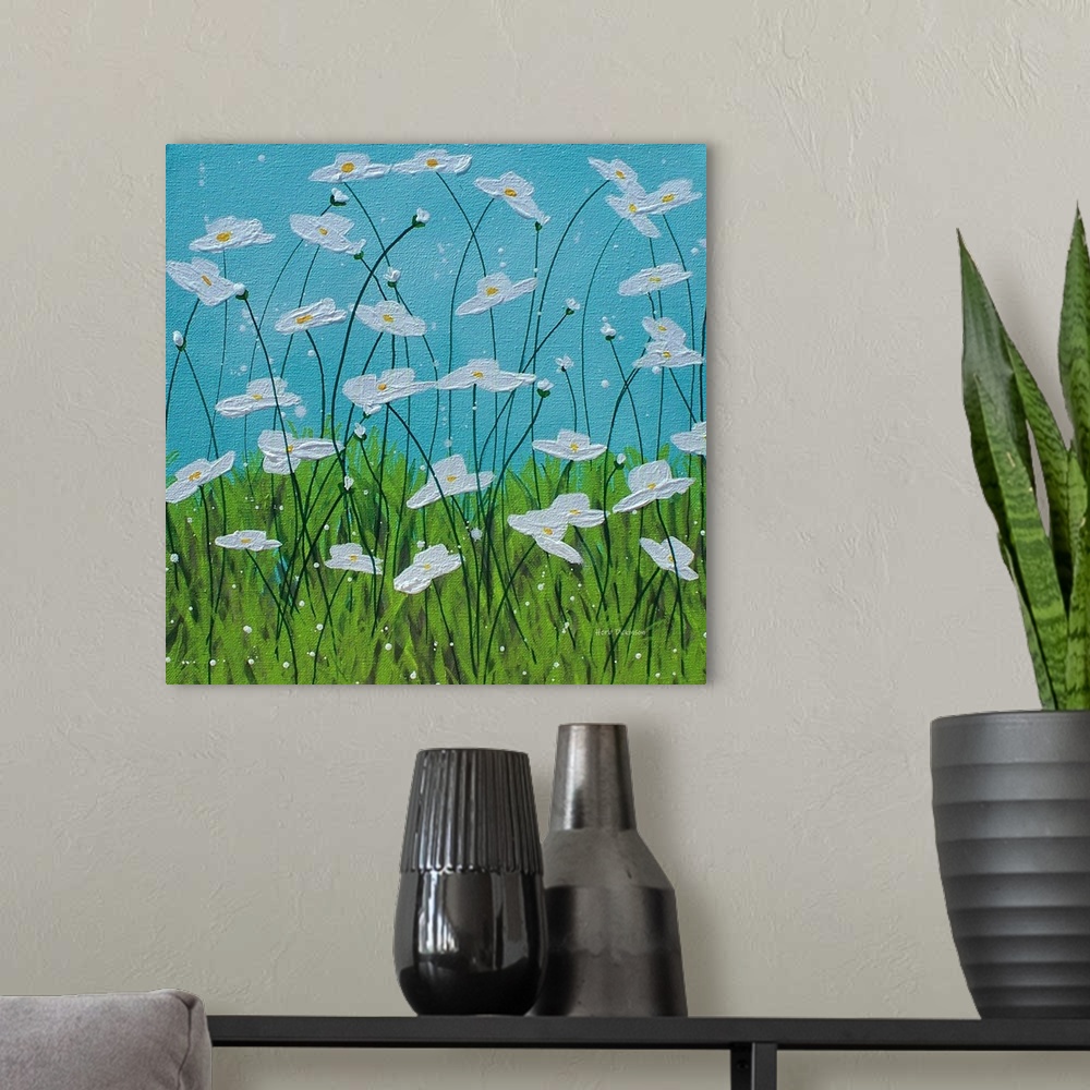 A modern room featuring Square painting of white flowers with long, thin stems in tall grass with a blue sky in the backg...