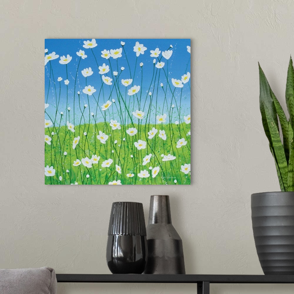 A modern room featuring Square painting of white daisies with long, thin stems in a field with a blue sky in the background.