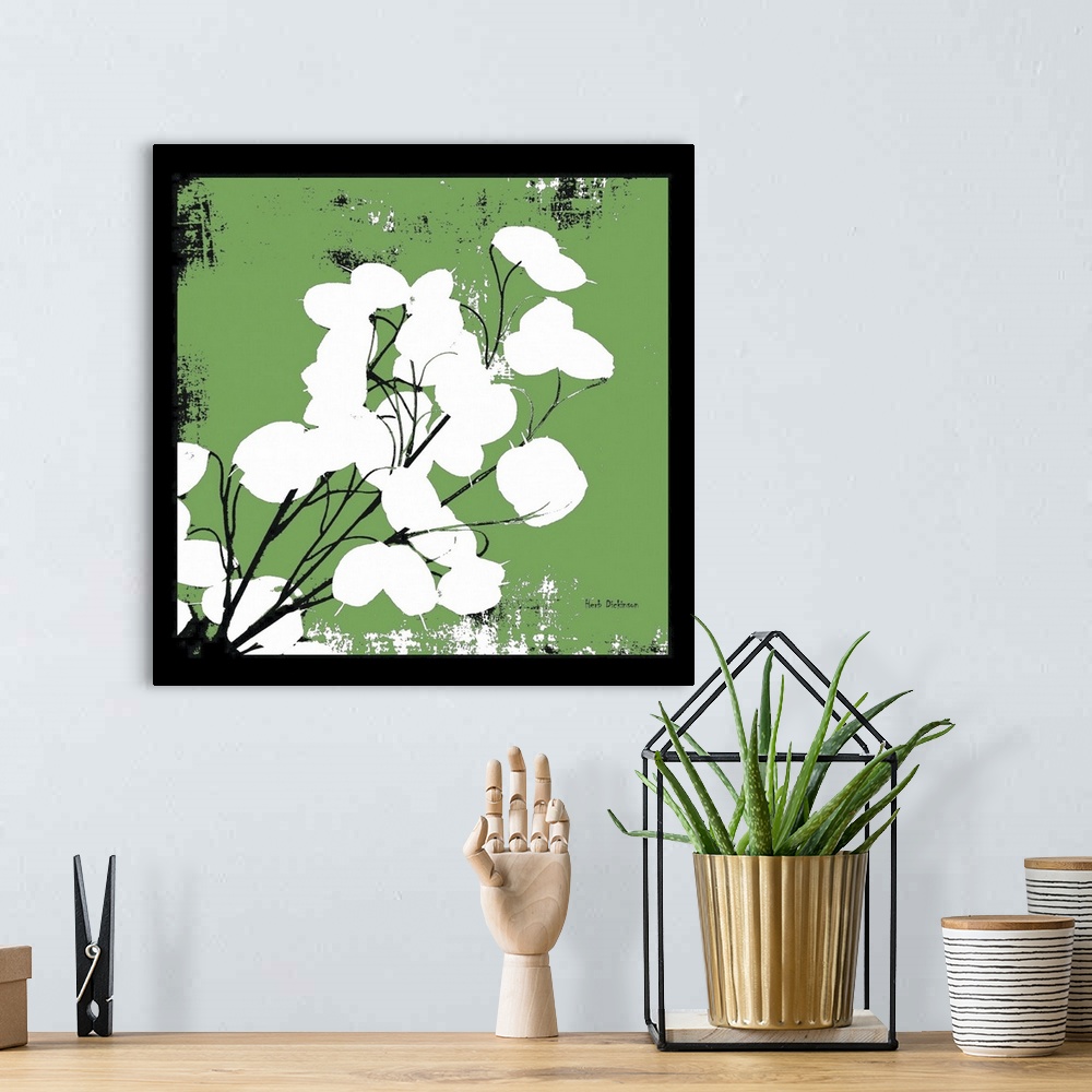 A bohemian room featuring Square silhouetted painting of a money plant in green, black, and white with a black boarder.