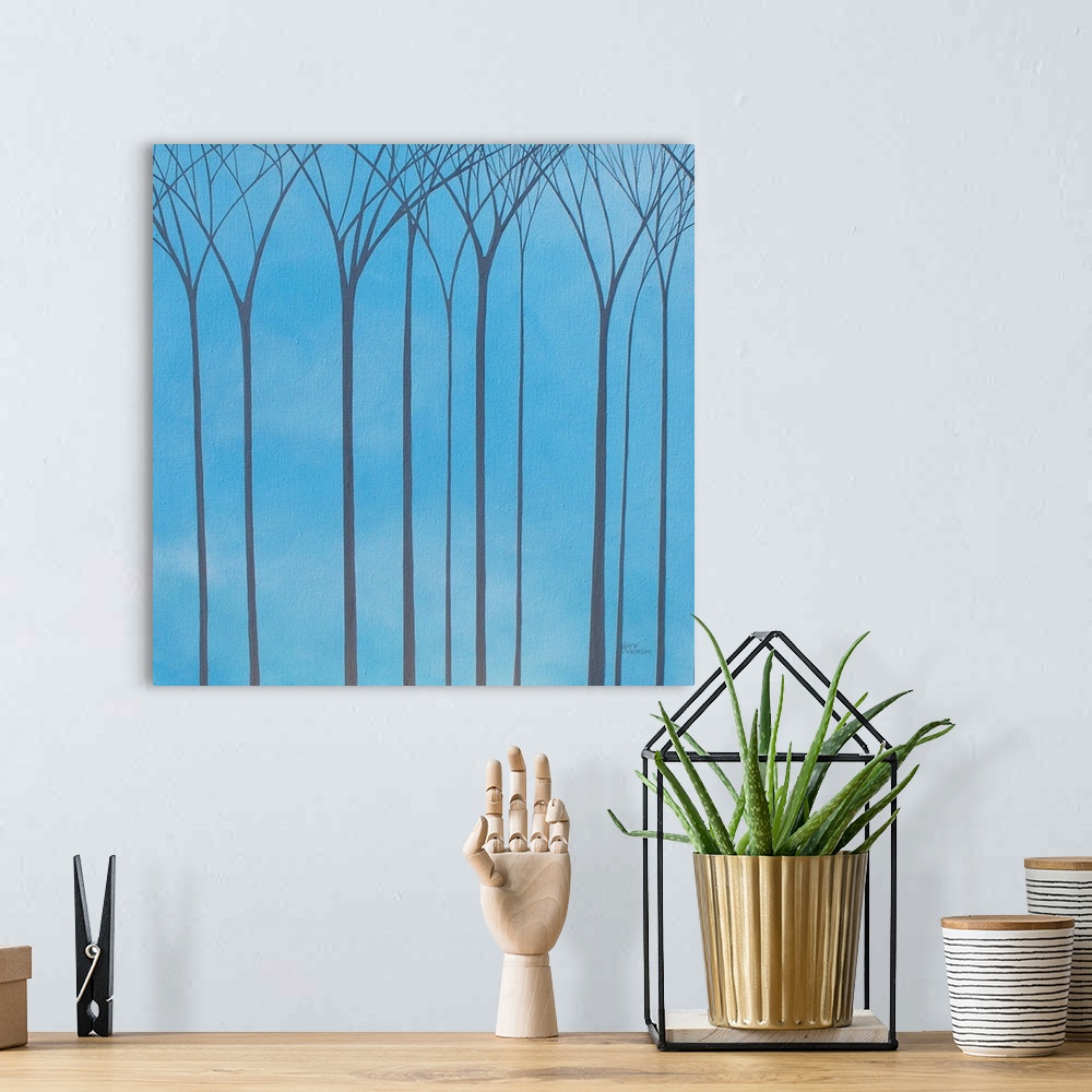A bohemian room featuring Tall, bare, gray, Winter trees on a blue background.