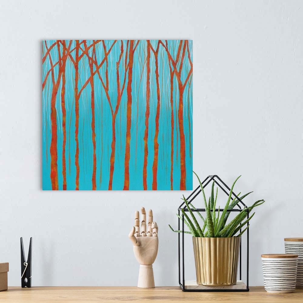 A bohemian room featuring Simple landscape painting with bare orange tree trunks and branches on a bright blue background.