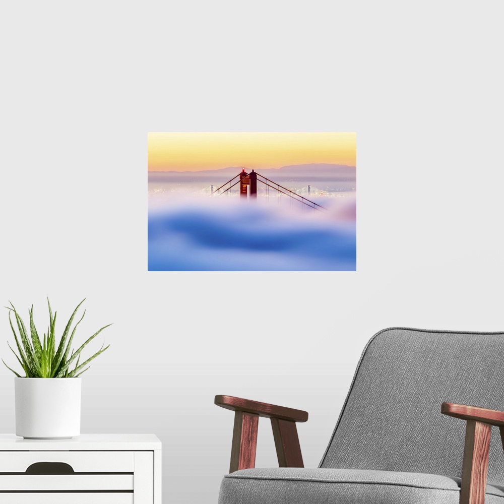 A modern room featuring A dynamic photograph of the golden gate bridge just barely making it above a thick blanket of clo...