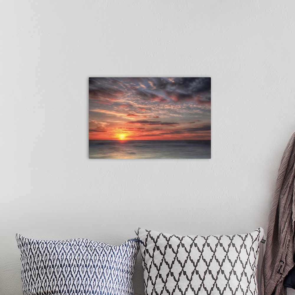 A bohemian room featuring A coastal photograph of a seascape at sunrise.