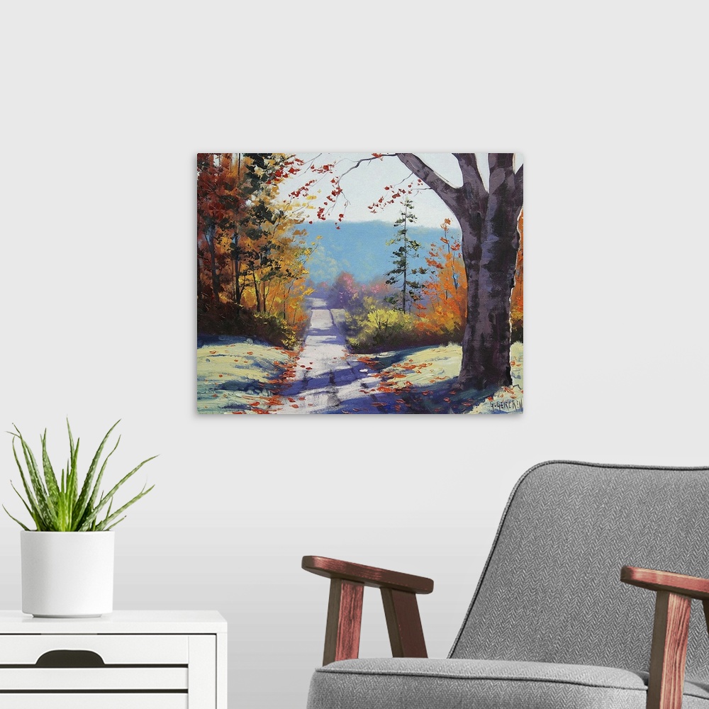 A modern room featuring Contemporary painting of an idyllic countryside landscape, with a road cutting through autumn fol...
