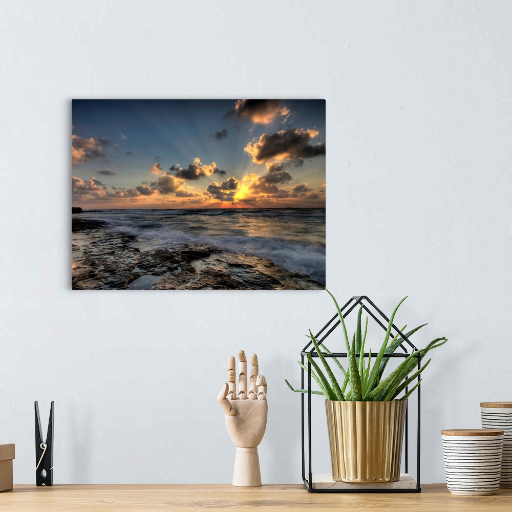A bohemian room featuring Horizontal photograph of a vibrant, golden sunset at a rocky beach.