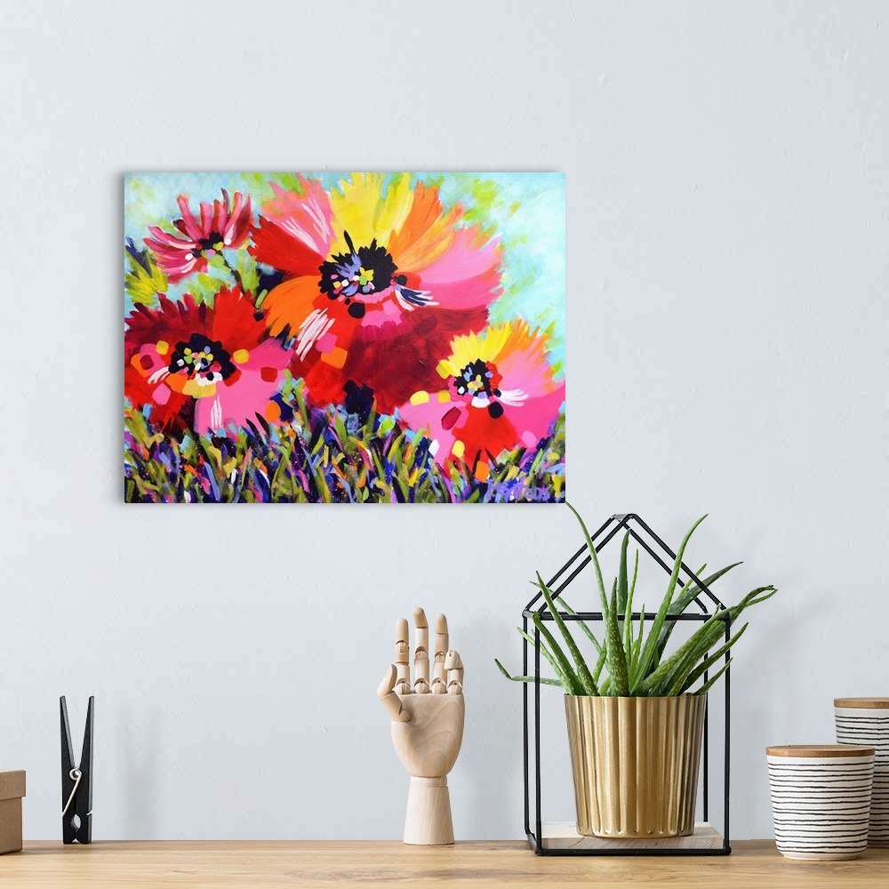 A bohemian room featuring A horizontal abstract painting of bright poppies in colors of yellow, red and pink.