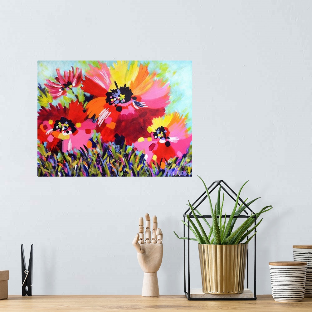 A bohemian room featuring A horizontal abstract painting of bright poppies in colors of yellow, red and pink.