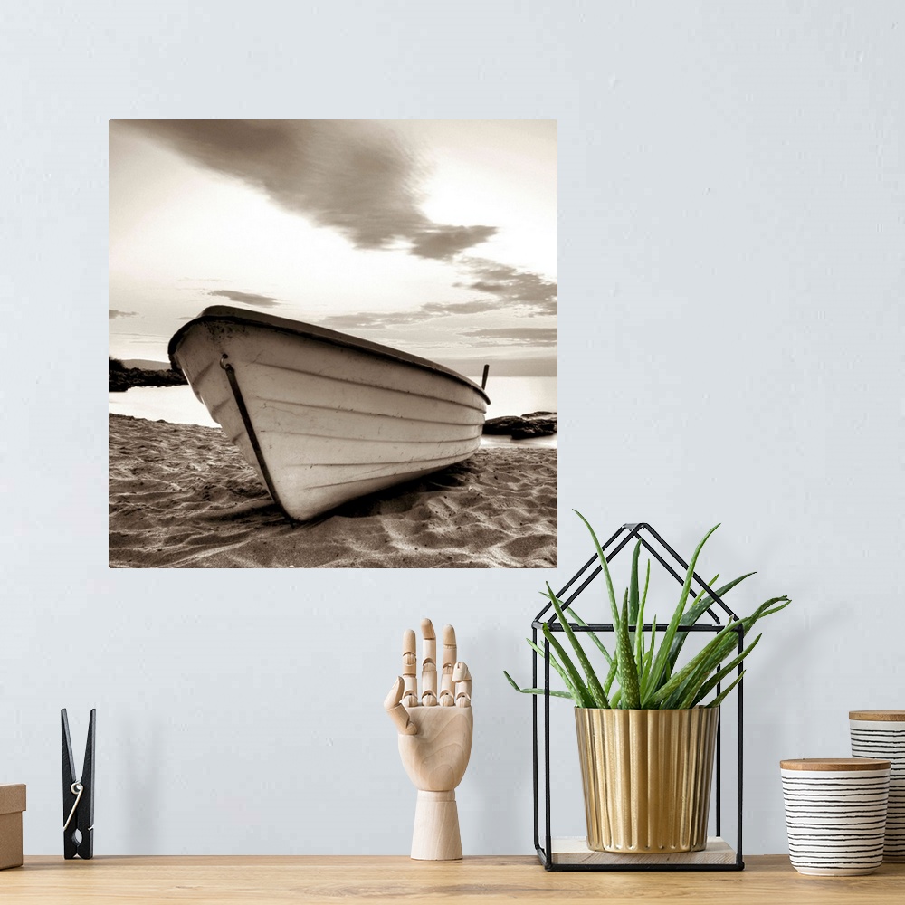 A bohemian room featuring A square image of a small white boat pulled up onto a sandy beach with a dramatic line of clouds ...