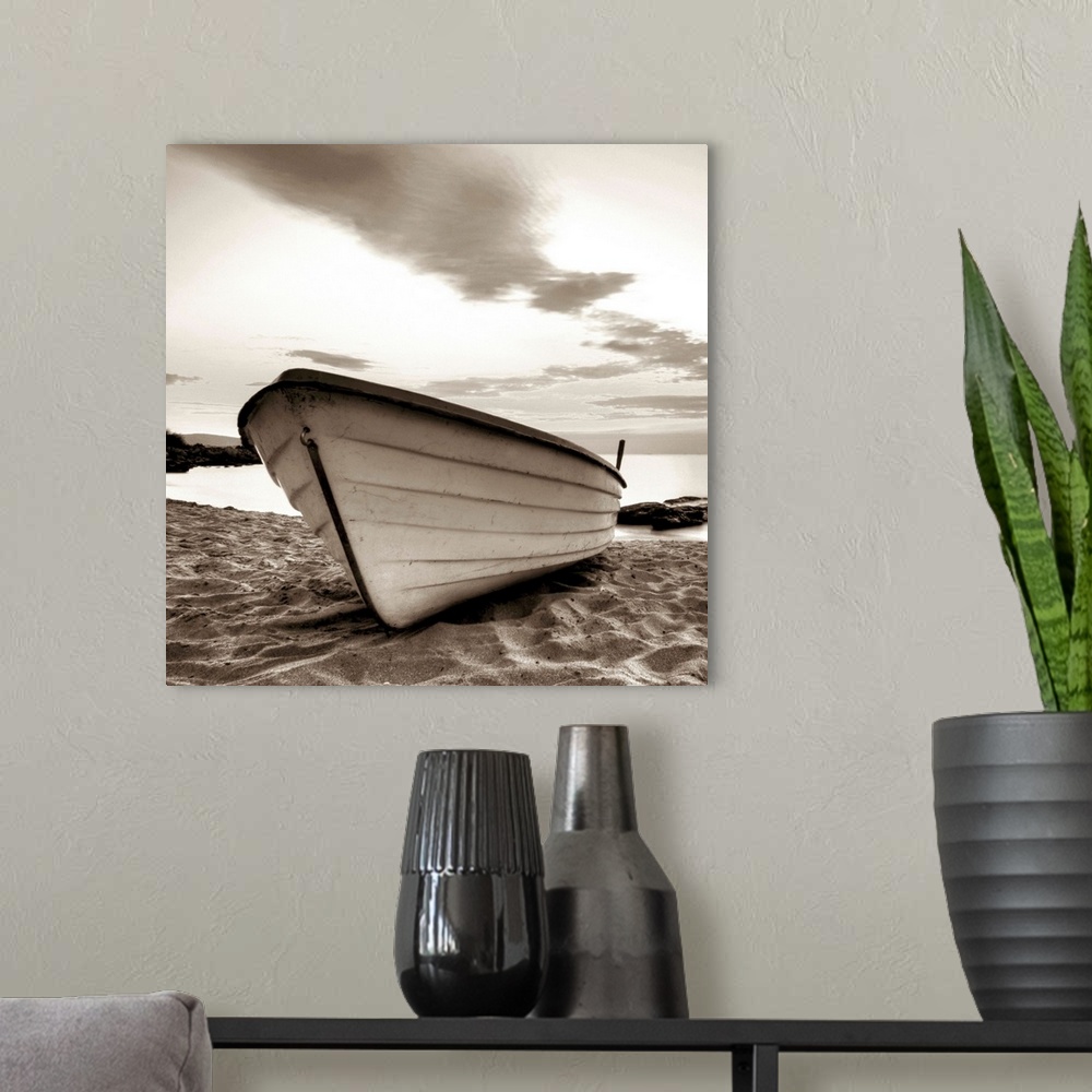 A modern room featuring A square image of a small white boat pulled up onto a sandy beach with a dramatic line of clouds ...