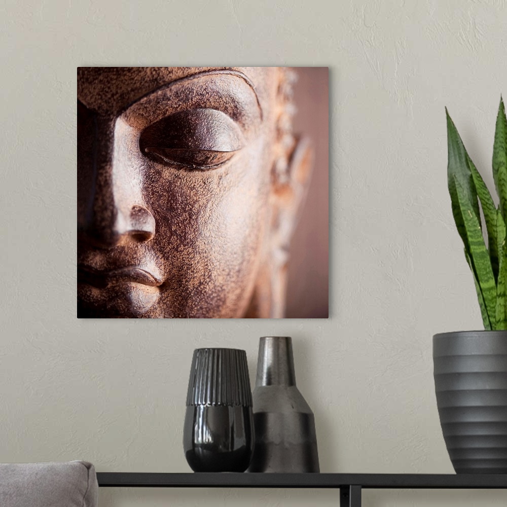 A modern room featuring Square close up photograph of a Buddha statue.
