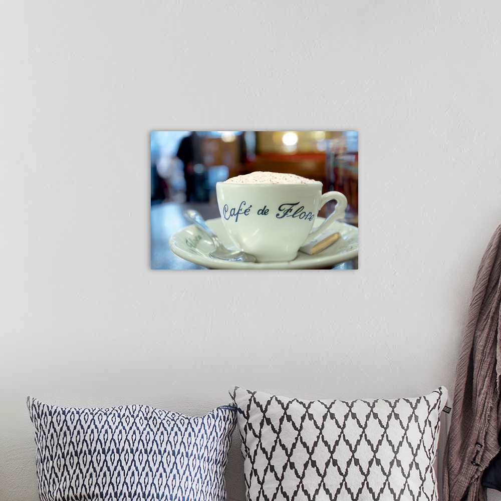 A bohemian room featuring A close up photograph of a cup of coffee from Cafe de Flore in Paris.