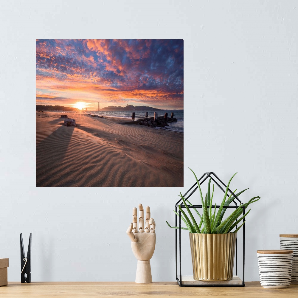 A bohemian room featuring A square photograph of a beach with the golden gate bridge in the background at sunset.