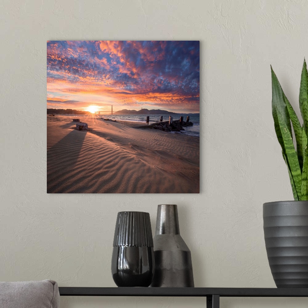 A modern room featuring A square photograph of a beach with the golden gate bridge in the background at sunset.