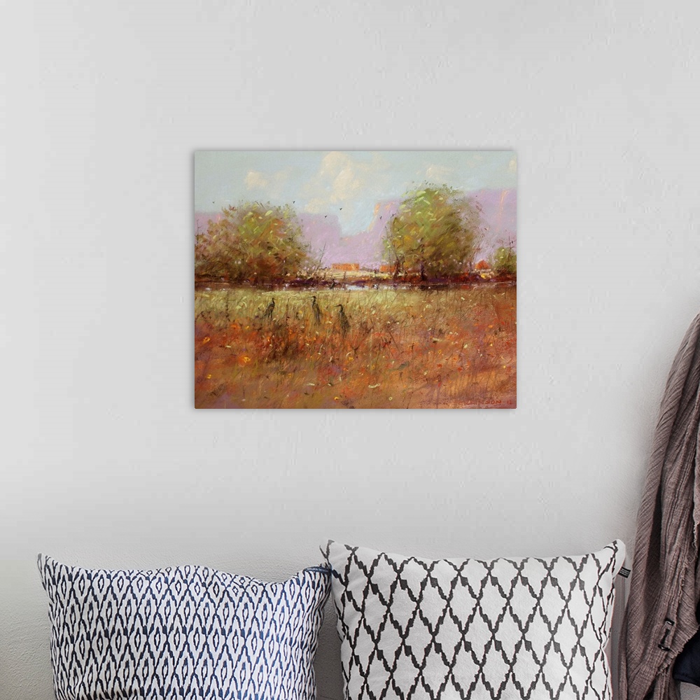 A bohemian room featuring A contemporary painting of a southwestern landscape with birds hiding in tall grass.