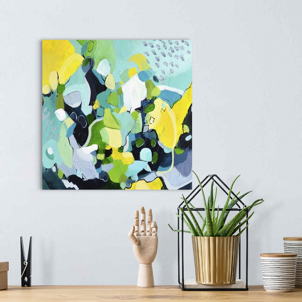 A bohemian room featuring Festive abstract painting with blue, green, and yellow shapes.