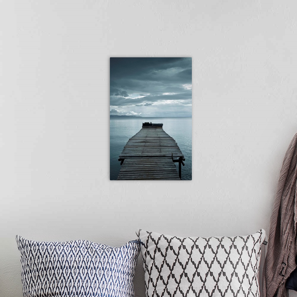 A bohemian room featuring Photograph of a weathered dock over calm water with dark clouds overhead.