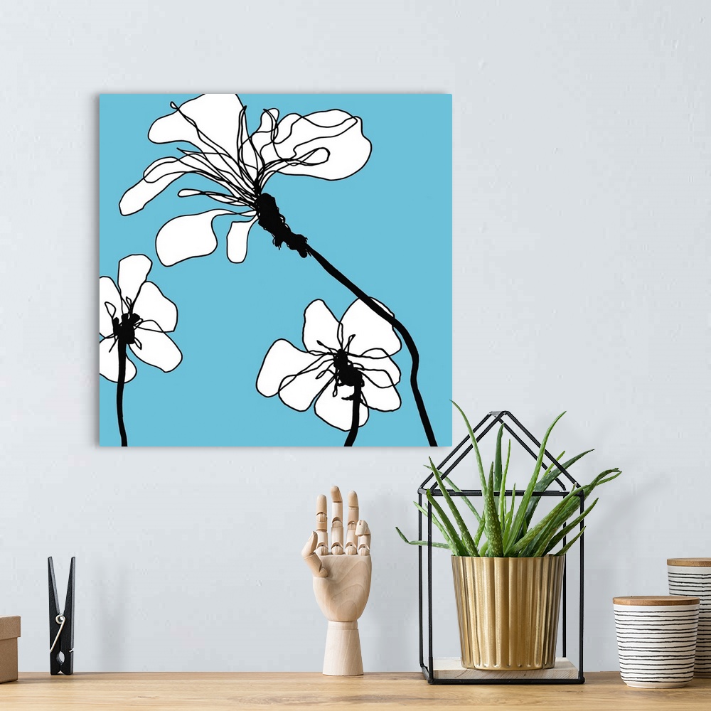 A bohemian room featuring Modern artwork of white flowers on a blue backdrop.